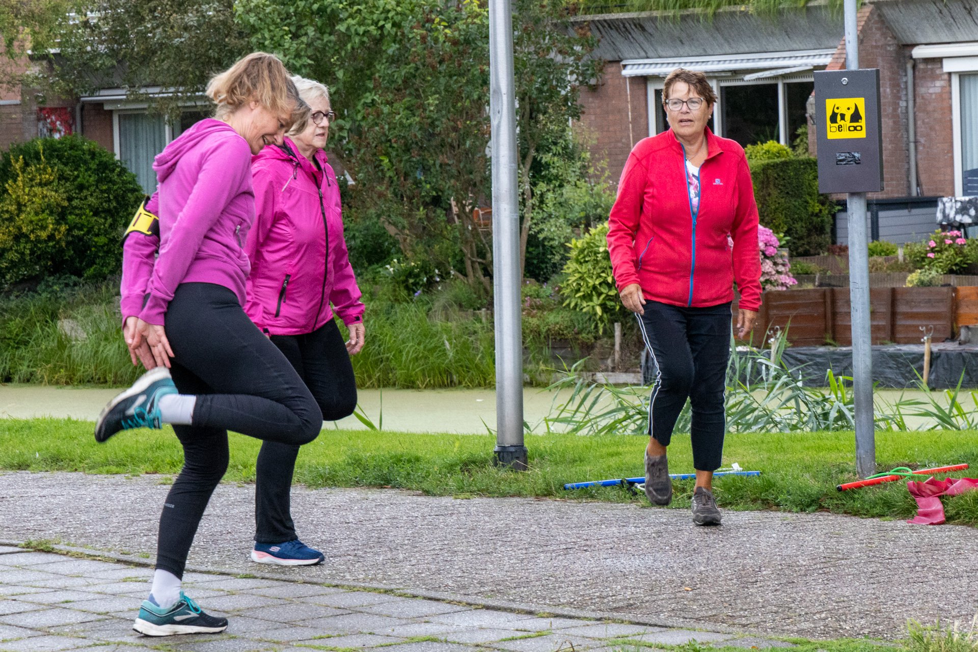 Drie vrouwen sportend in felle sportkleren op straat