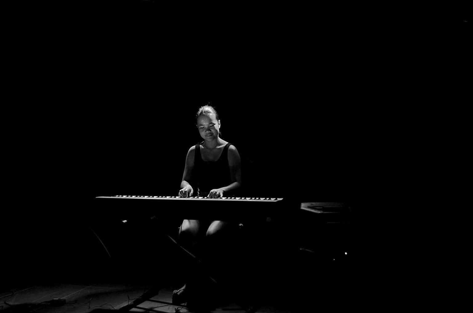 Meisje die in het donker piano speelt